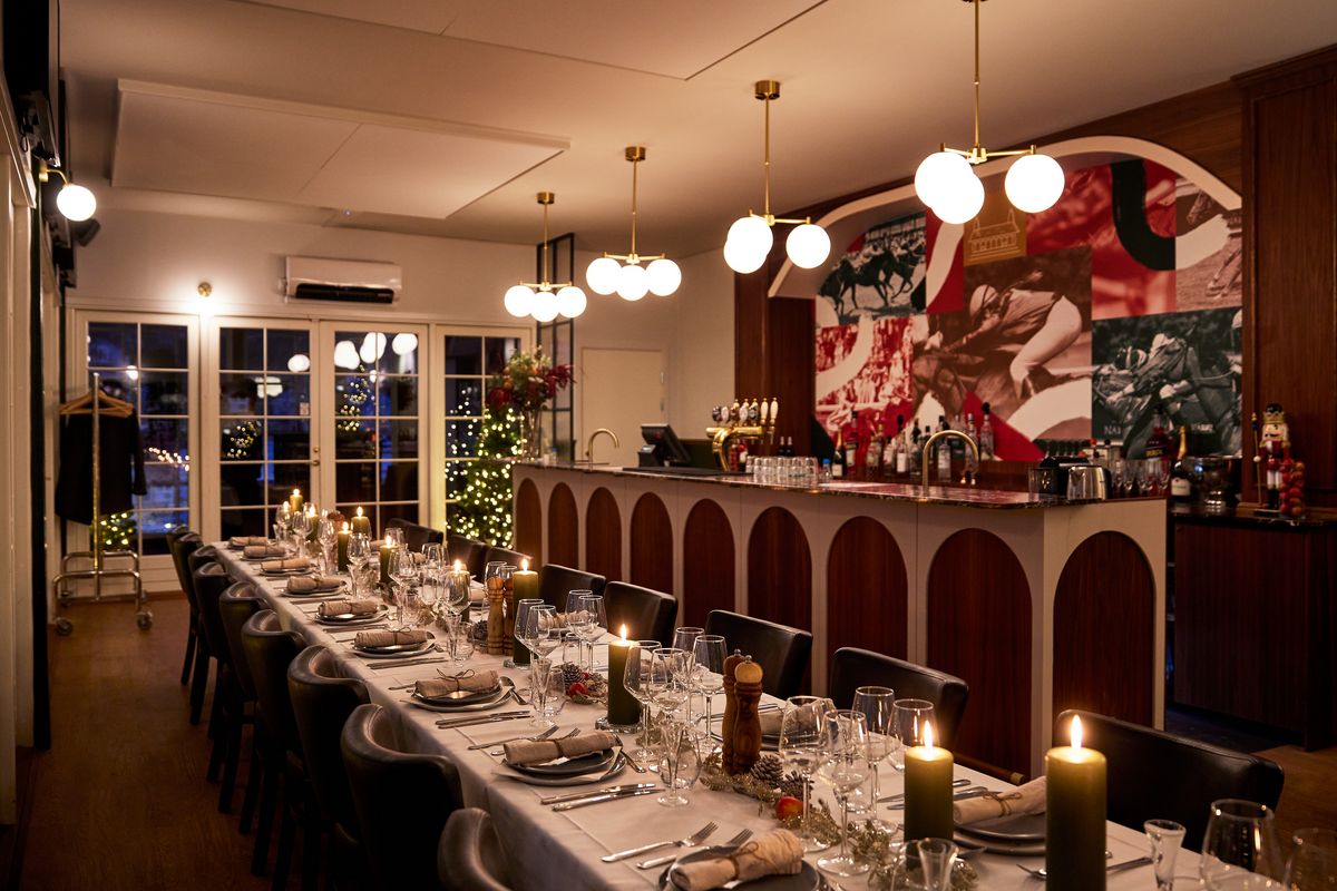 Julefrokostlokale med langbord og stemningsfuld belysning